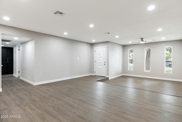 spare room with recessed lighting, visible vents, baseboards, and wood finished floors