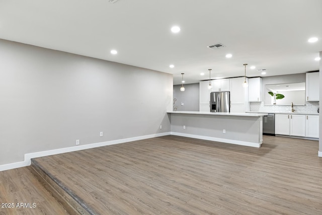 kitchen featuring visible vents, white cabinets, decorative backsplash, appliances with stainless steel finishes, and light countertops