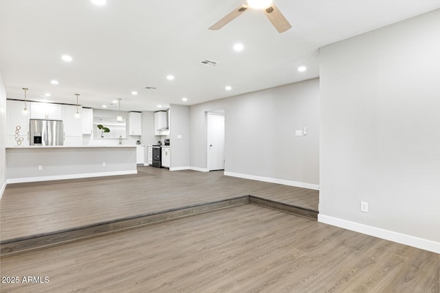 unfurnished living room with light wood-style flooring, baseboards, ceiling fan, and recessed lighting