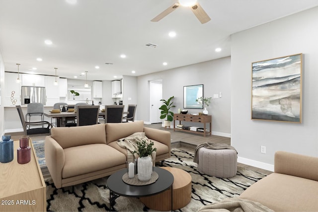 living room with ceiling fan, recessed lighting, wood finished floors, visible vents, and baseboards