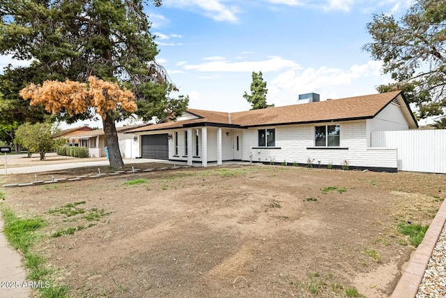 single story home featuring brick siding, fence, driveway, and an attached garage