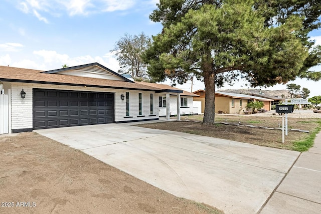 ranch-style house with a garage, concrete driveway, and brick siding