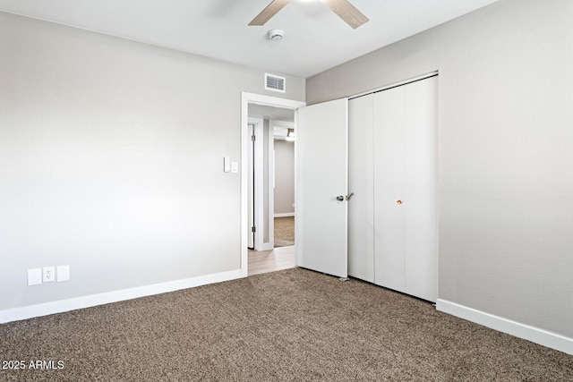 unfurnished bedroom with carpet, a closet, visible vents, ceiling fan, and baseboards