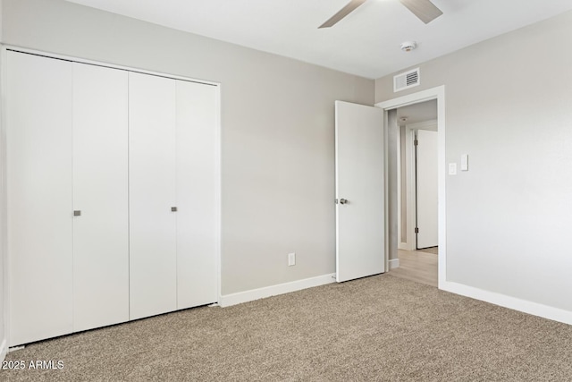 unfurnished bedroom featuring ceiling fan, carpet flooring, visible vents, baseboards, and a closet