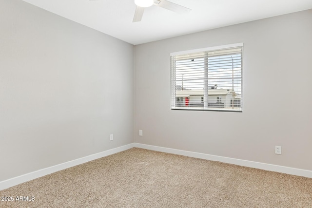 spare room featuring baseboards, a ceiling fan, and light colored carpet