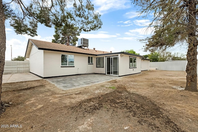 rear view of house with fence, a patio, and central AC unit