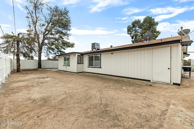 rear view of property featuring a fenced backyard and central AC unit