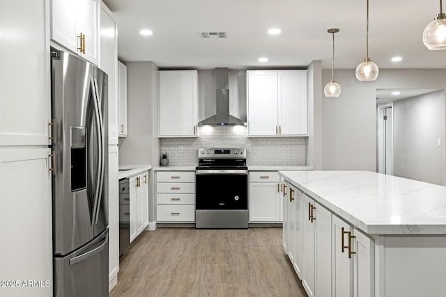 kitchen with stainless steel appliances, white cabinetry, light wood-style floors, visible vents, and wall chimney exhaust hood