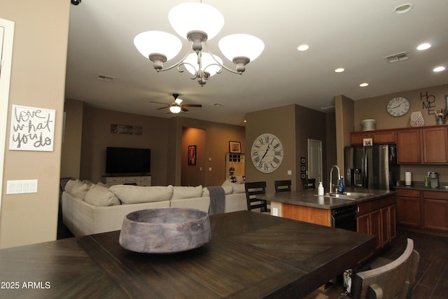 dining room featuring dark hardwood / wood-style flooring, sink, and ceiling fan with notable chandelier