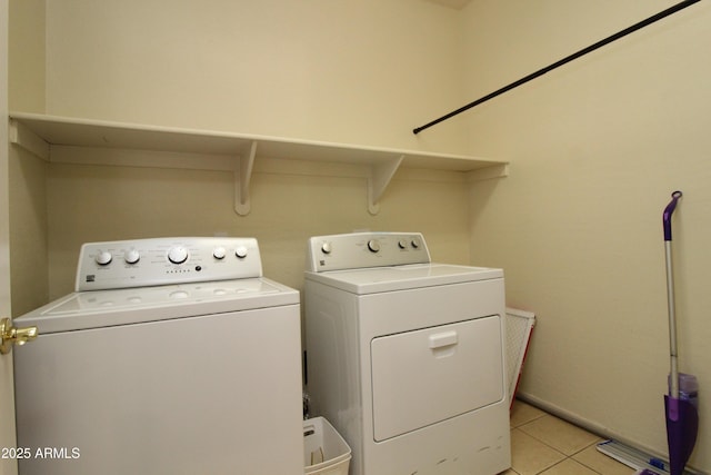 laundry area featuring washing machine and dryer and light tile patterned flooring