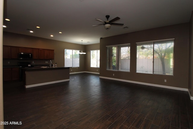 unfurnished living room with sink, dark wood-type flooring, and ceiling fan