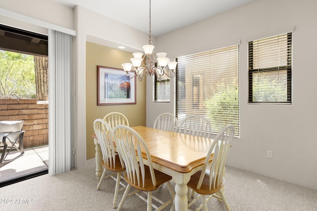 carpeted dining space with a chandelier