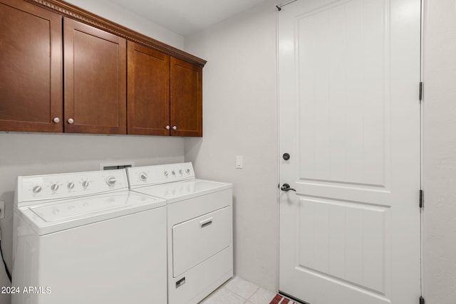 laundry area with cabinets, washer and dryer, and light tile patterned floors