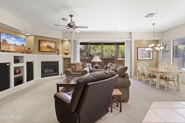 living room with light carpet and ceiling fan with notable chandelier