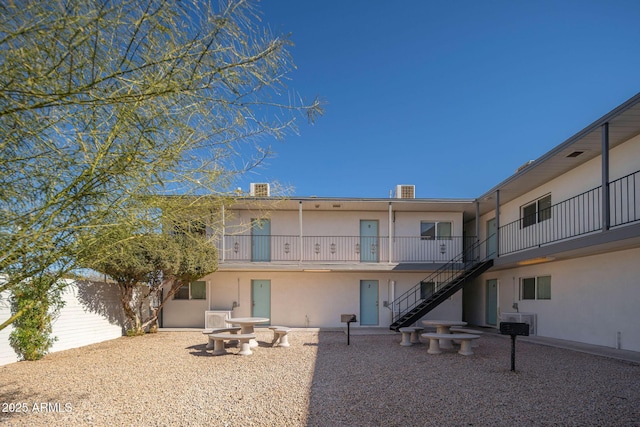 5623 W Myrtle Ave, Glendale, AZ 85301 - rear view of house with stairs, a patio area, central AC, and stucco siding