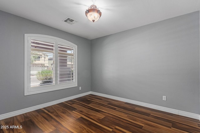 unfurnished room with dark wood-style floors and baseboards