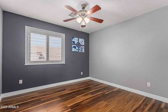 spare room with dark wood-style floors, baseboards, and ceiling fan