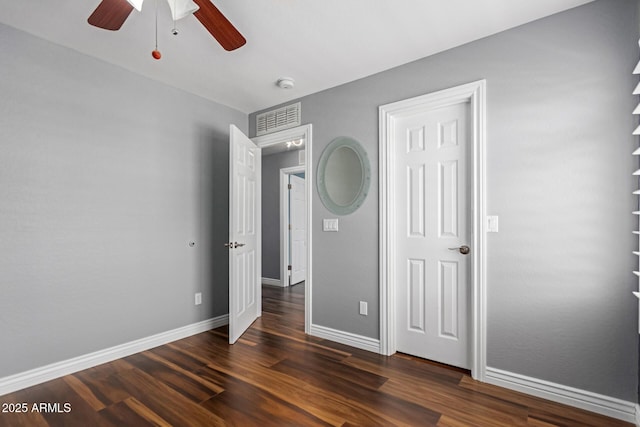 unfurnished bedroom featuring dark wood-style flooring, baseboards, and a ceiling fan