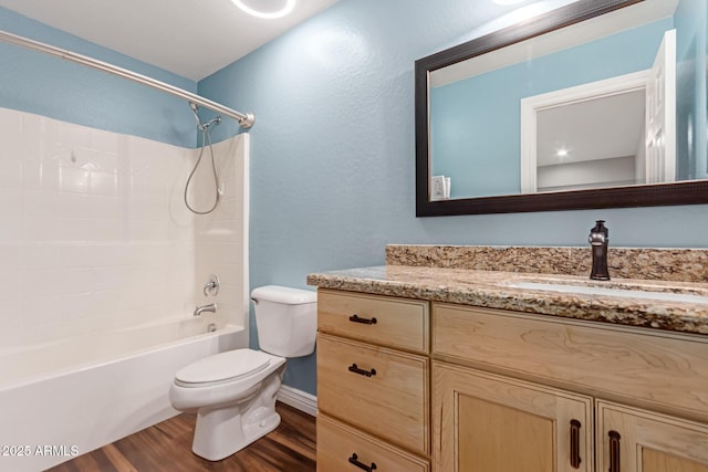 full bathroom featuring wood finished floors, toilet, vanity, washtub / shower combination, and baseboards