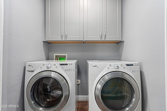laundry room with washing machine and clothes dryer and cabinet space