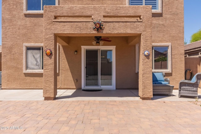 view of exterior entry featuring a patio and a ceiling fan