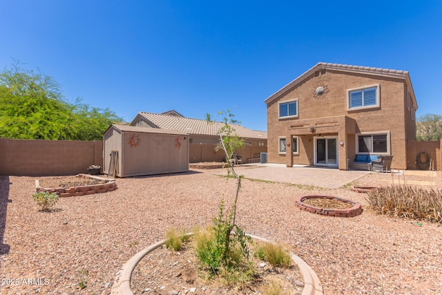 back of house with a storage shed, a patio, and a fenced backyard