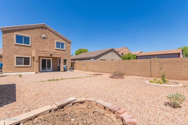 back of property with a fenced backyard and a patio area