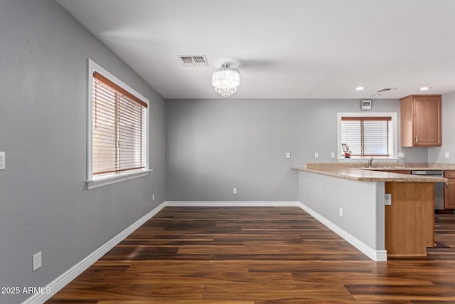kitchen with stainless steel dishwasher, dark wood finished floors, baseboards, and recessed lighting