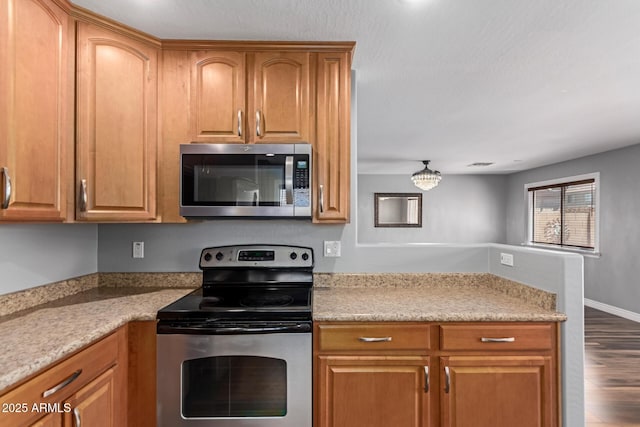 kitchen featuring stainless steel appliances, light countertops, dark wood-type flooring, and brown cabinetry