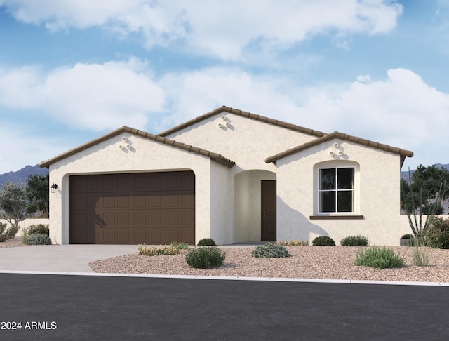 mediterranean / spanish-style home featuring a garage, a tile roof, concrete driveway, and stucco siding