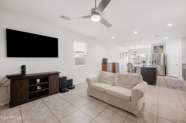 tiled living room featuring a healthy amount of sunlight, sink, and ceiling fan