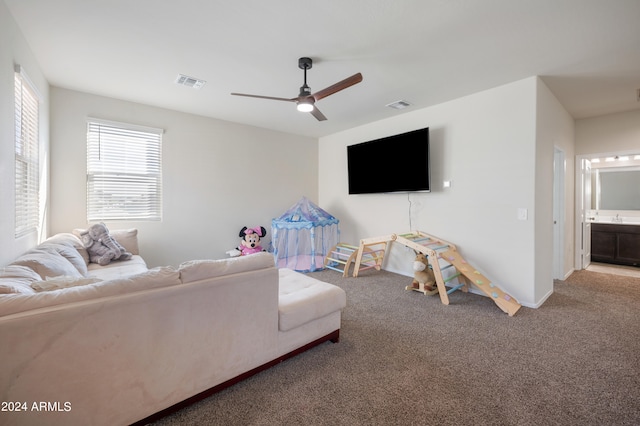 carpeted living room with ceiling fan