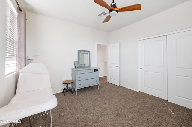 sitting room featuring ceiling fan and dark colored carpet