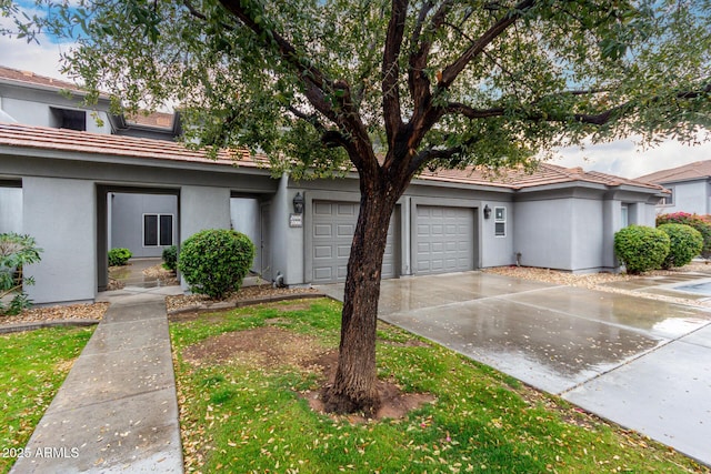 multi unit property with stucco siding, a tiled roof, and concrete driveway