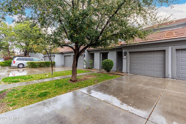 view of property with stucco siding, concrete driveway, and a garage