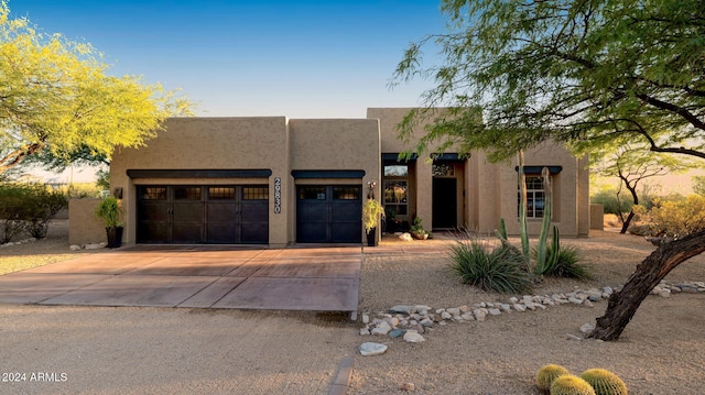 pueblo revival-style home with a garage