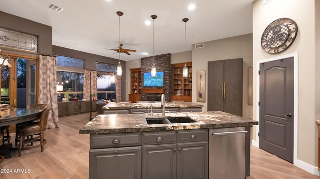 kitchen featuring a kitchen island with sink, sink, ceiling fan, and light hardwood / wood-style flooring