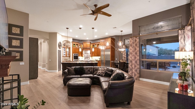 living room with ceiling fan and light wood-type flooring