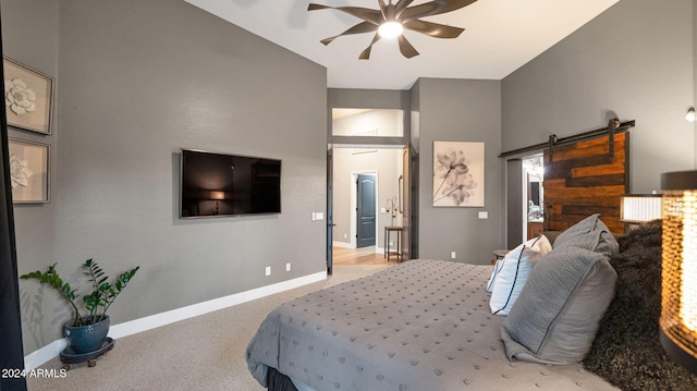 bedroom featuring light carpet, a barn door, and ceiling fan