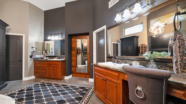 bathroom with vanity, tile patterned flooring, and a towering ceiling