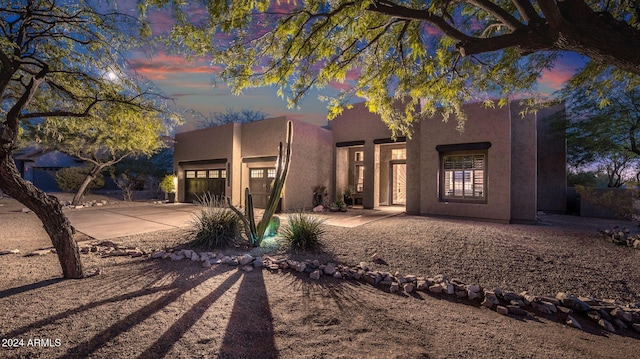 pueblo revival-style home featuring a garage