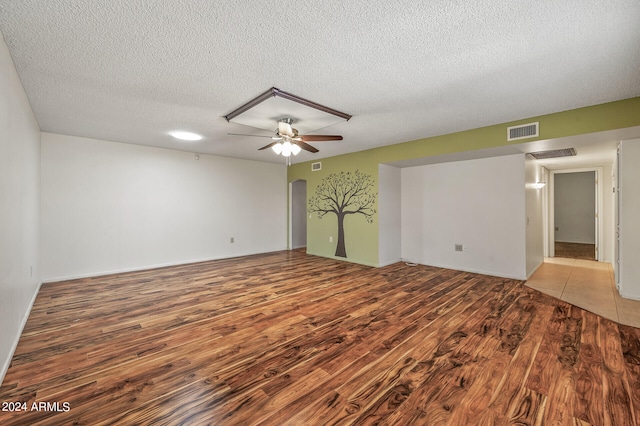 spare room featuring wood-type flooring, a textured ceiling, and ceiling fan