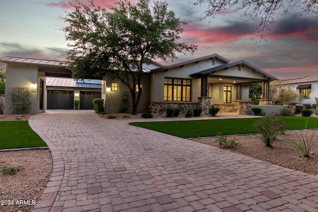 view of front of home with a garage and a lawn