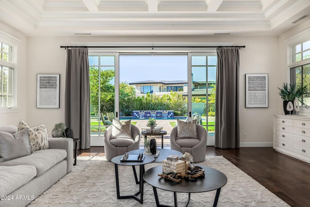 living room with a healthy amount of sunlight, dark wood-type flooring, crown molding, and coffered ceiling