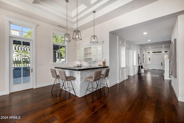 dining room featuring dark hardwood / wood-style floors, ornamental molding, a towering ceiling, and a tray ceiling