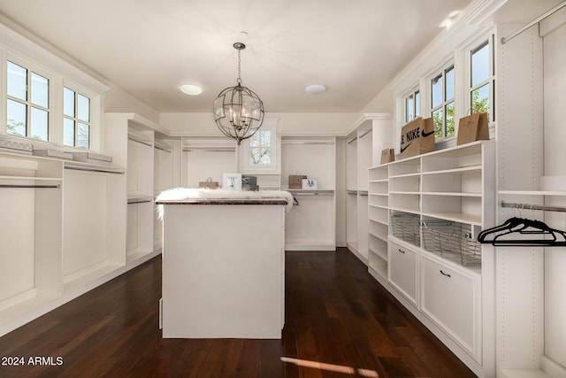 spacious closet featuring a chandelier and dark wood-type flooring