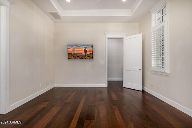 interior space with a raised ceiling, dark wood-type flooring, and crown molding