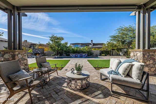 view of patio with an outdoor living space with a fireplace