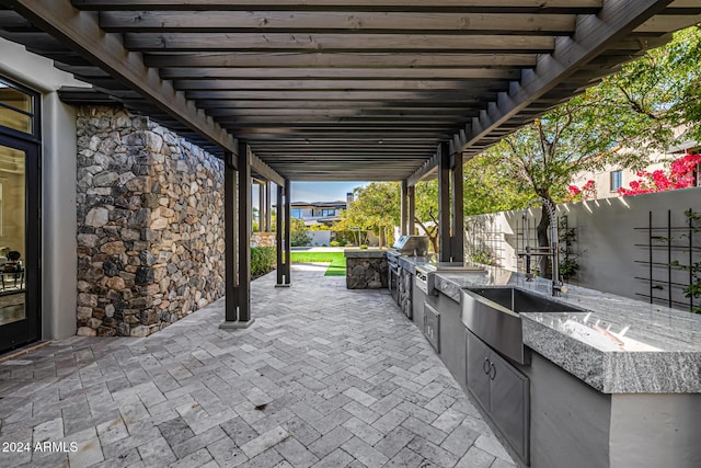 view of patio / terrace featuring a pergola, grilling area, and exterior kitchen