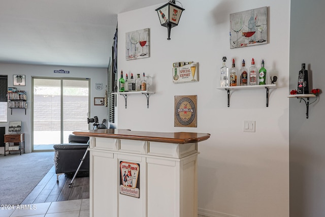 bar featuring light carpet and white cabinets